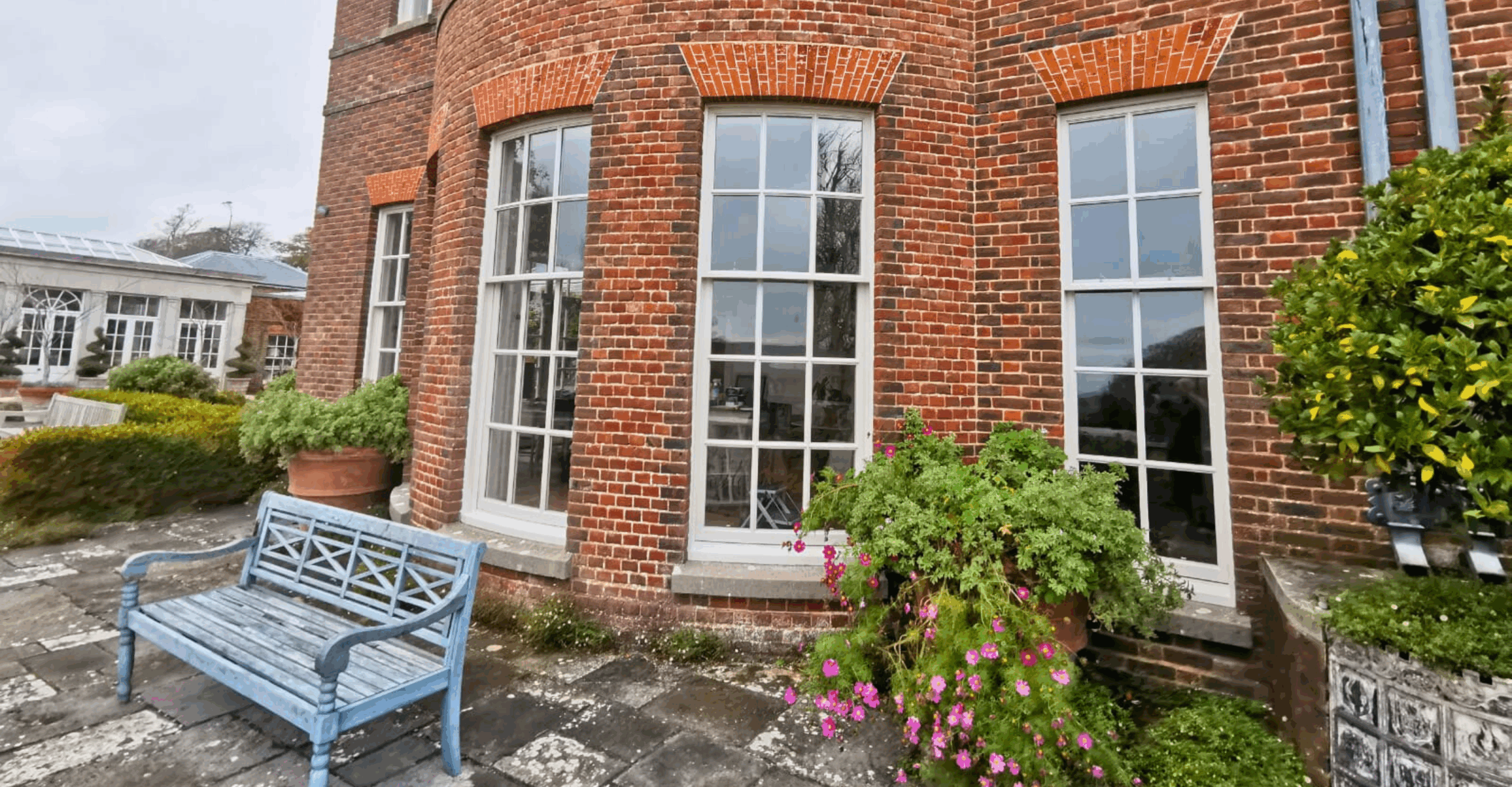 Exterior view of fully restored sash windows in red brick building in Lulworth